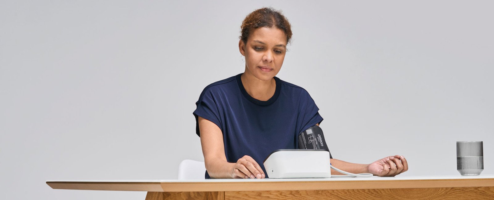 Woman taking blood pressure monitor at home