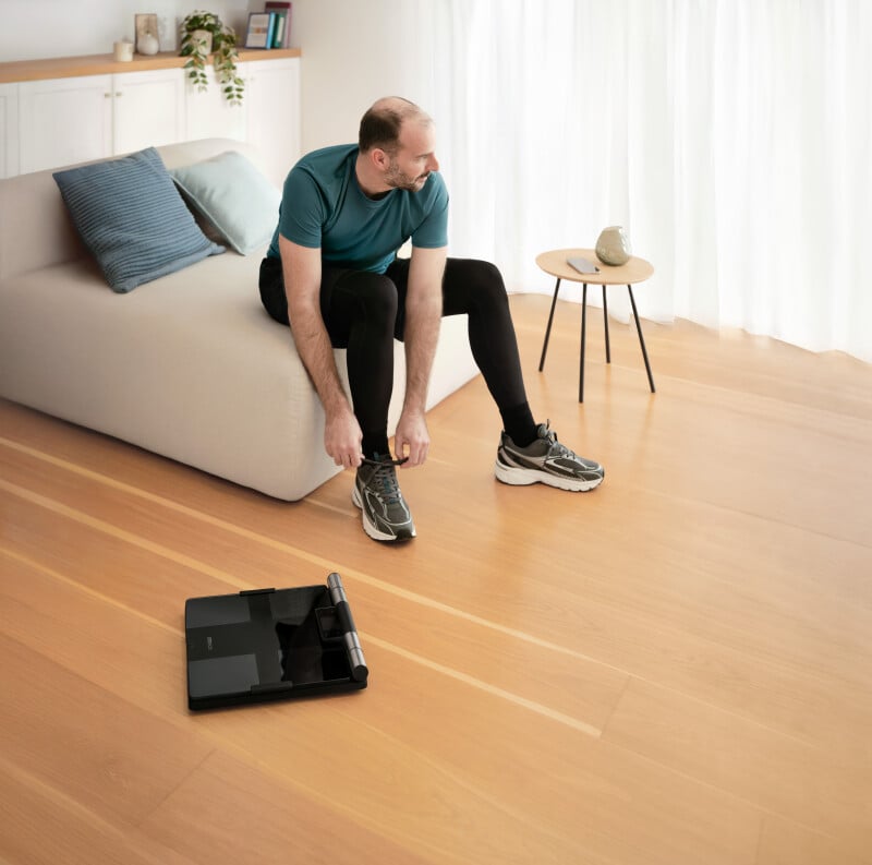Man tying his shoe and VIVA 360 is on the floor next to him