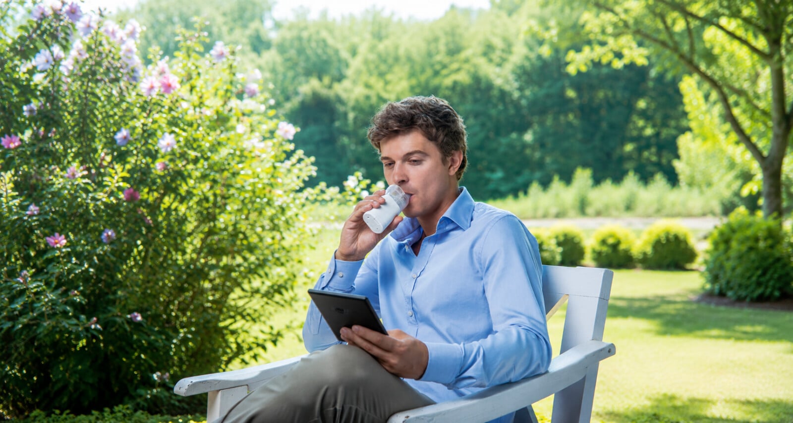 Man sitting in a chair outside using a nebulizer