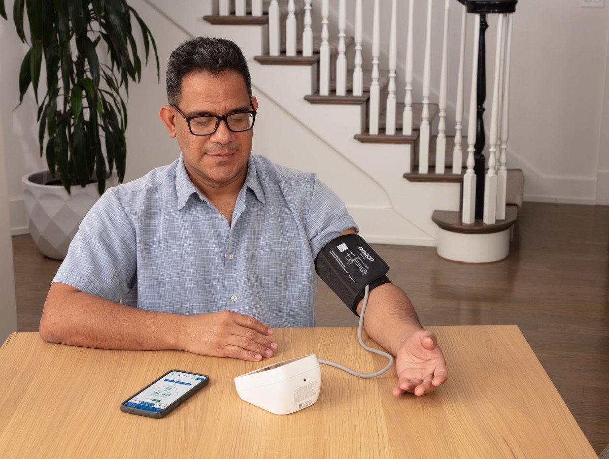 Man taking blood pressure monitor at home