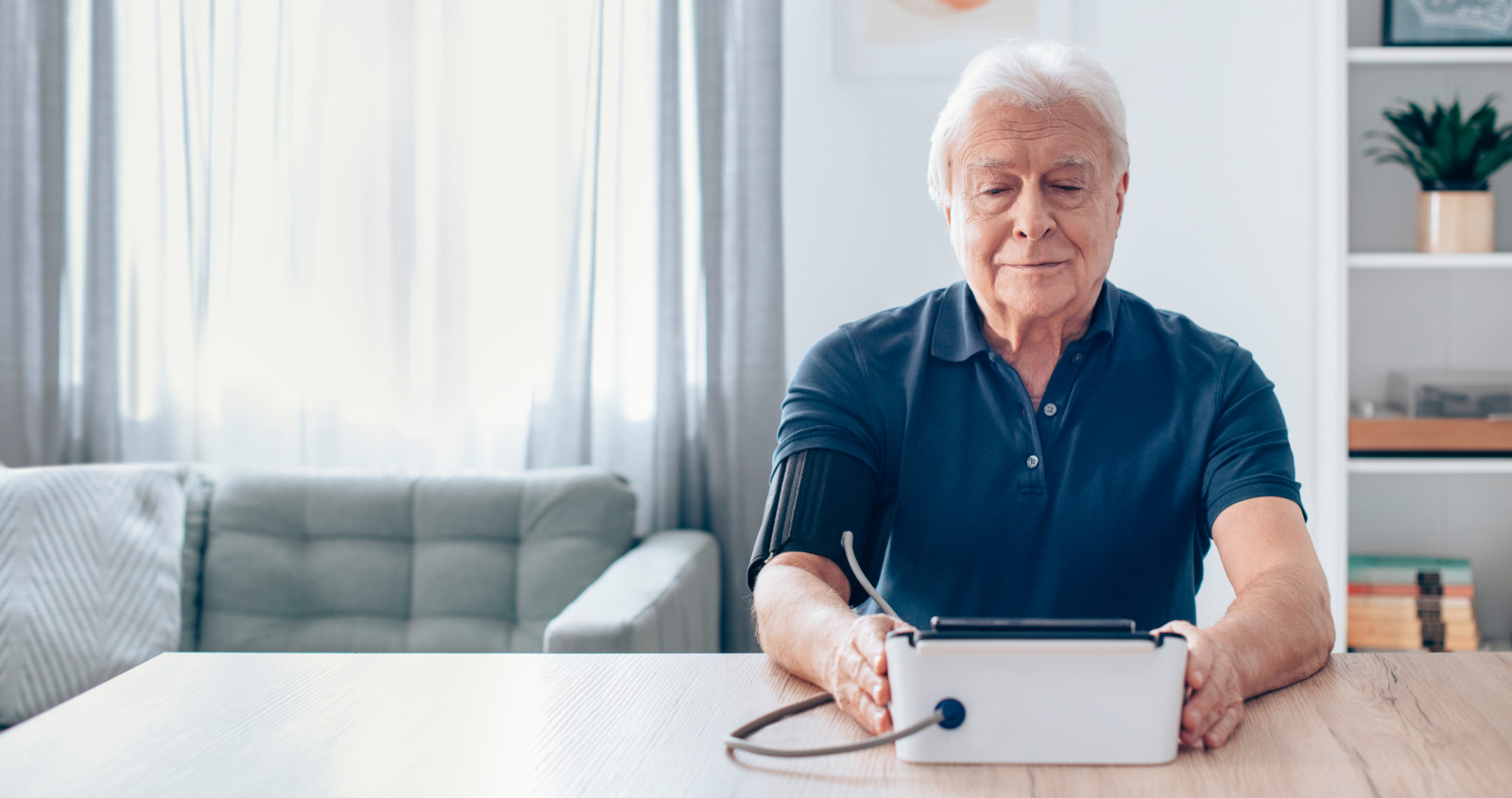 Man taking blood pressure and EKG with monitor at home